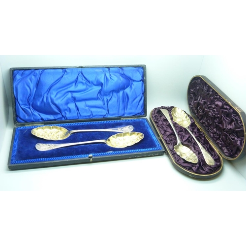 922 - A cased set of two silver berry spoons, (not matching hallmarks) 98g, and a plated pair