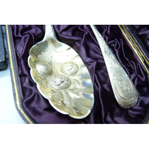 922 - A cased set of two silver berry spoons, (not matching hallmarks) 98g, and a plated pair