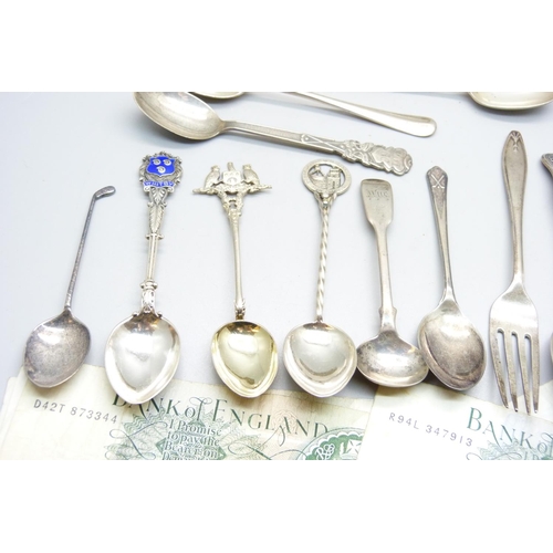 954 - Seven £1 banknotes, assorted silver teaspoons, coffee spoons and souvenir spoons, 275g