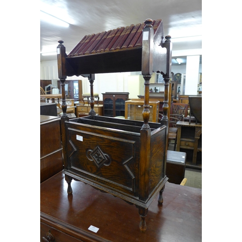 100 - An early 20th Century oak bookstand, with fifteen books