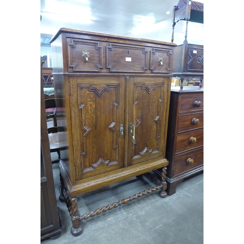 104 - An early 20th Century oak geometric moulded cupboard on barleytwist stand