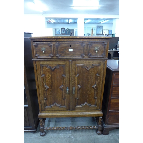 104 - An early 20th Century oak geometric moulded cupboard on barleytwist stand