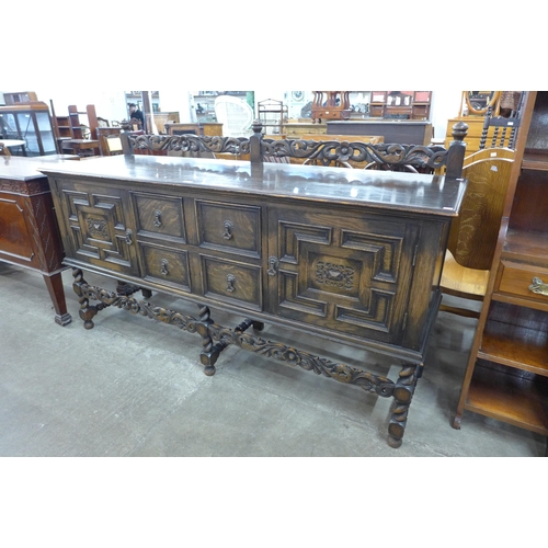 110 - An early 20th century Jacobean Revival carved oak geometric moulded barleytwist sideboard