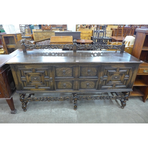 110 - An early 20th century Jacobean Revival carved oak geometric moulded barleytwist sideboard