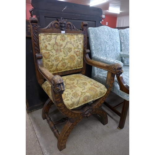 132 - A 17th Century style carved oak and fabric upholstered green man x-frame chair