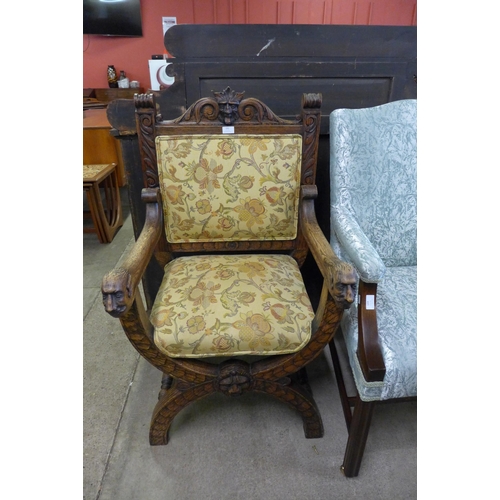 132 - A 17th Century style carved oak and fabric upholstered green man x-frame chair