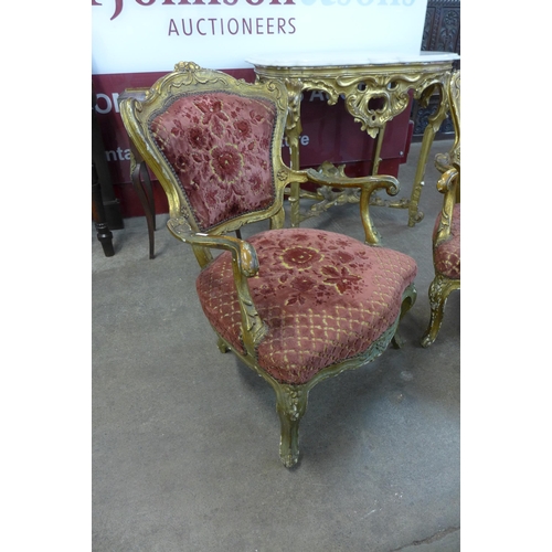 14 - A pair of French Louis XIV style carved giltwood and fabric upholstered fauteuil chairs