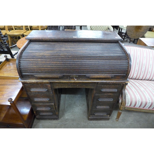 180 - An early 20th Century oak tambour roll top desk