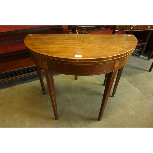 25 - A George III inlaid mahogany demi-lune fold over tea table