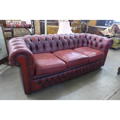 29A - An oxblood red leather Chesterfield settee