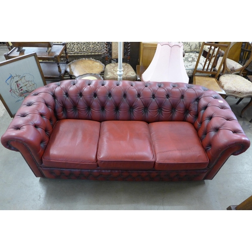 29A - An oxblood red leather Chesterfield settee