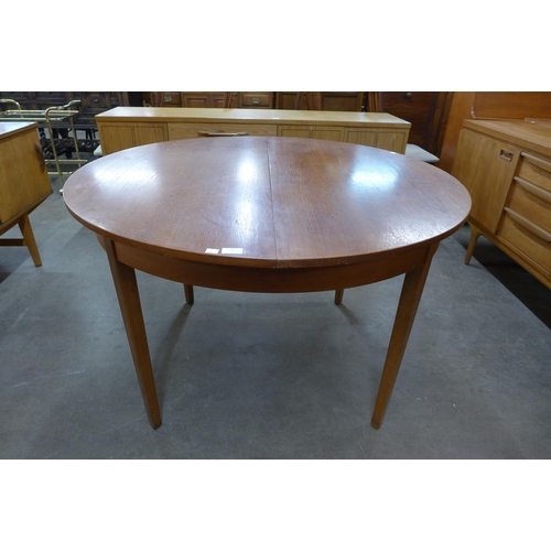 56 - A circular teak extending dining table