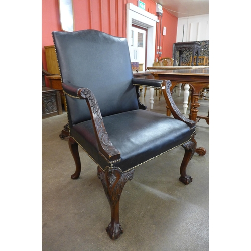 9 - A George III style carved mahogany and black leather upholstered Gainsborough chair