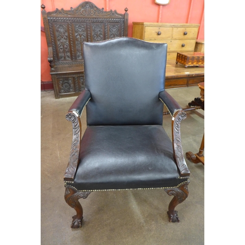 9 - A George III style carved mahogany and black leather upholstered Gainsborough chair