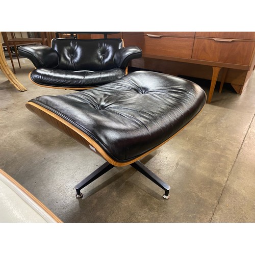 34 - A Ray & Charles Eames style simulated rosewood and black leather revolving lounge chair and ottoman