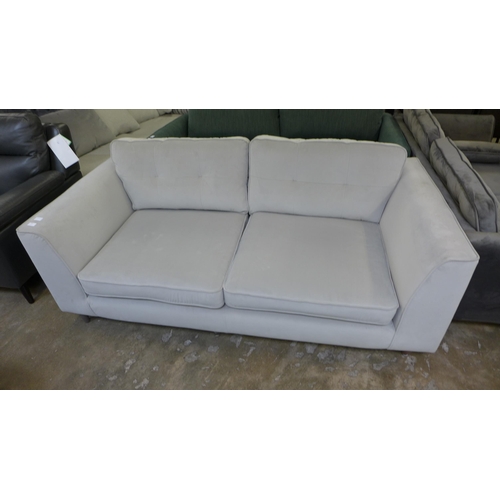 1459 - A stone grey velvet upholstered pinched back three seater sofa