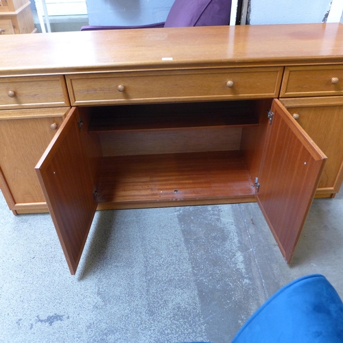 1661 - A teak four door, three drawer sideboard