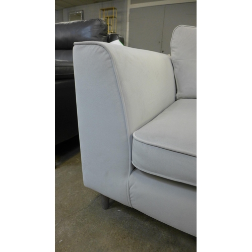 1301 - A stone grey velvet upholstered pinched back three seater sofa