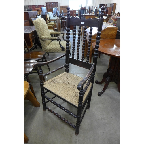 152 - An Arts and Crafts stained beech rush seated armchair