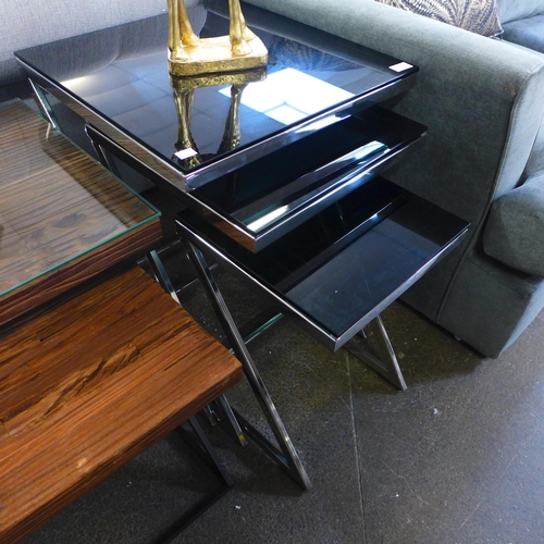 1390 - A black glass top nest of three tables