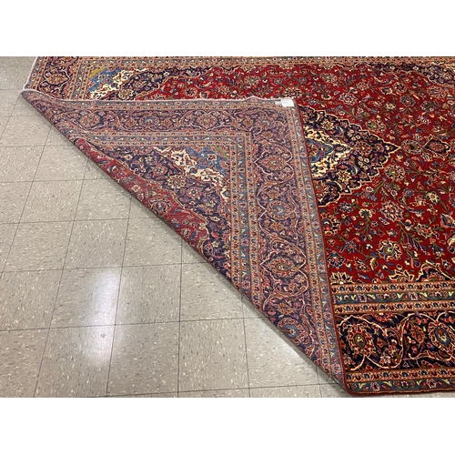 102 - A large Persian red ground Kashan rug, 409 x 294cms