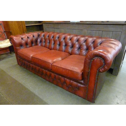 115 - An oxblood red leather Chesterfield settee