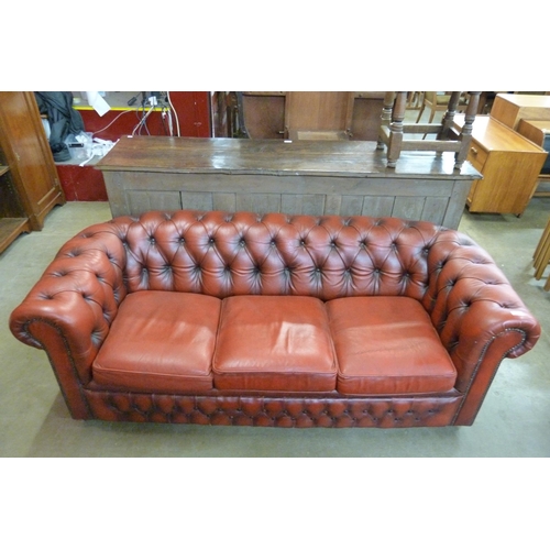 115 - An oxblood red leather Chesterfield settee