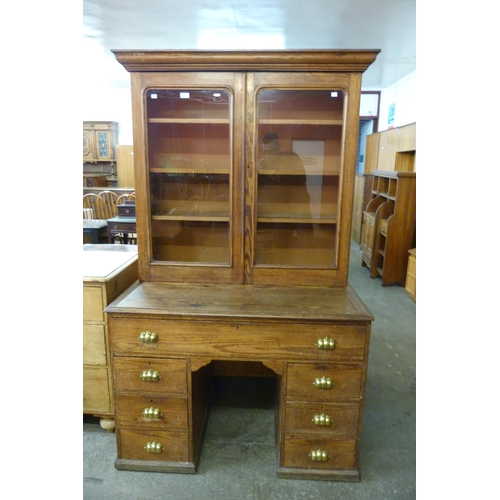 125 - A Victorian pitch pine bookcase on desk