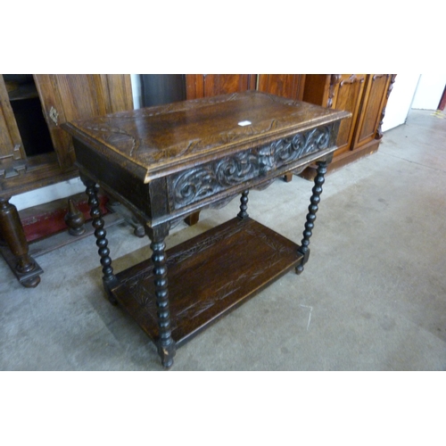 126 - A 17th Century style carved oak single drawer Greenman side table