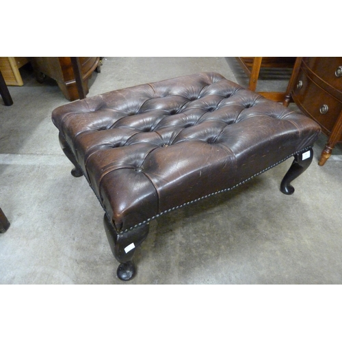 141 - A chestnut brown leather Chesterfield footstool