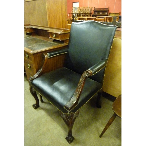 145 - A George III style carved mahogany and black leather upholstered Gainsborough chair