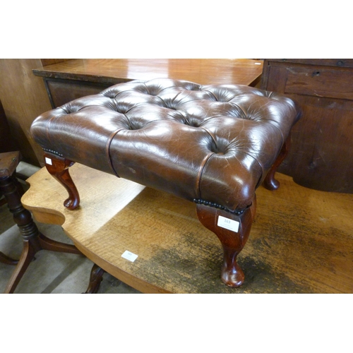 163 - A chestnut brown leather Chesterfield footstool