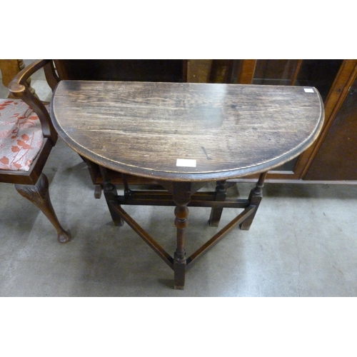 164 - An oak drop-leaf demi lune hall table