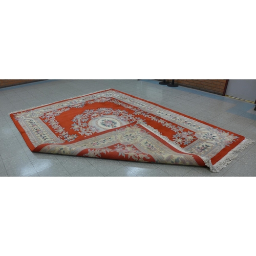 225 - A large Chinese red ground rug, 393 x 275cms