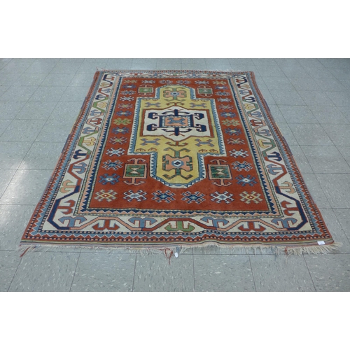 246 - An eastern terracotta ground rug, 209 x 176cms