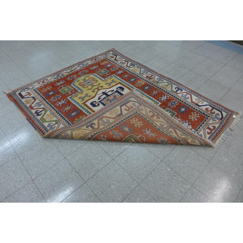 246 - An eastern terracotta ground rug, 209 x 176cms