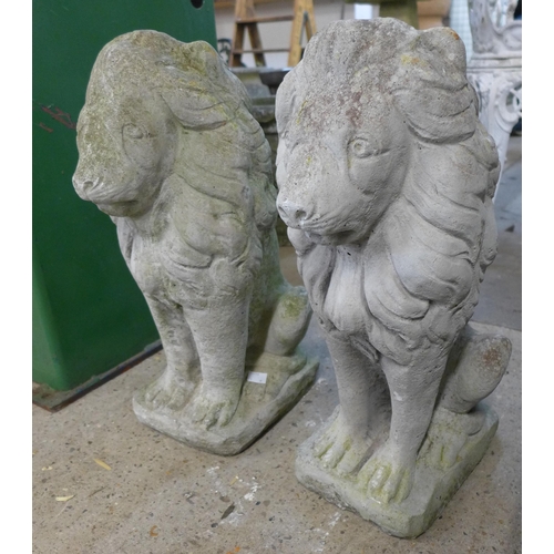 256 - A pair of concrete garden figures of seated lions