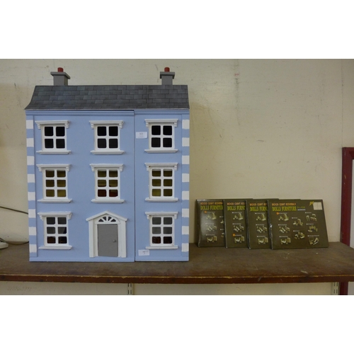 322 - A wooden doll's house, including furniture and four assembly sets of furniture