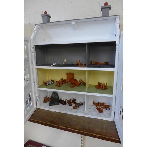 322 - A wooden doll's house, including furniture and four assembly sets of furniture