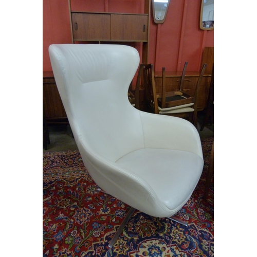 99 - A Frovi cream leather and chrome revolving lounge chair, manner of Arne Jacobsen