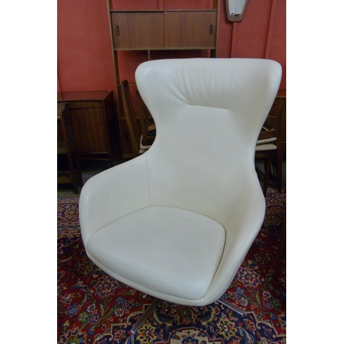 99 - A Frovi cream leather and chrome revolving lounge chair, manner of Arne Jacobsen