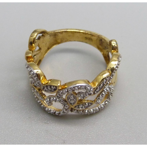 1040 - A pierced silver gilt ring set with a diamond accent, K