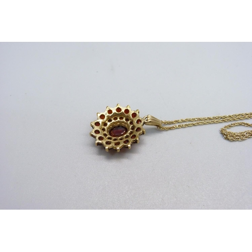 1047 - A yellow metal and garnet pendant on a 9ct gold chain, chain 1.8g