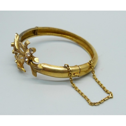 1087 - A yellow metal bangle, set with white sapphires, tests as high carat gold, 16.6g