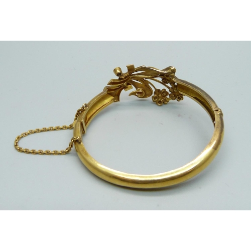 1087 - A yellow metal bangle, set with white sapphires, tests as high carat gold, 16.6g