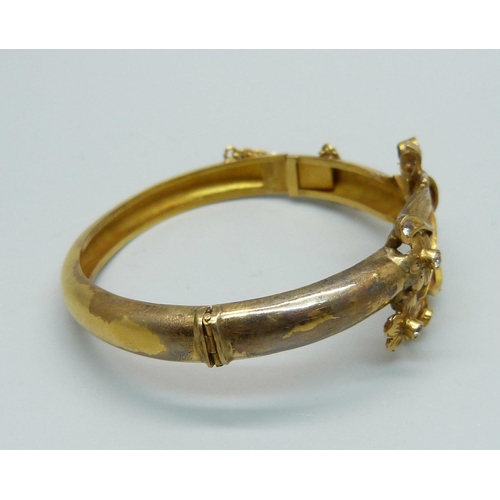 1087 - A yellow metal bangle, set with white sapphires, tests as high carat gold, 16.6g