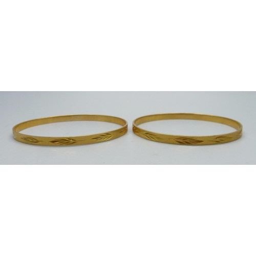 1090 - Two yellow metal bangles, test as high carat gold, 22.2g