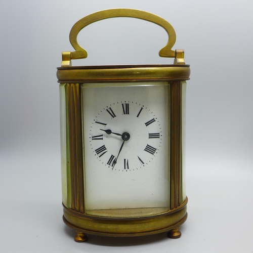 642 - A French carriage clock, oval case with travel case and key