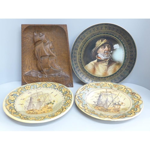 677 - An Arts and Crafts style carved wooden plaque, two Portuguese plates and a charger with portrait of ... 