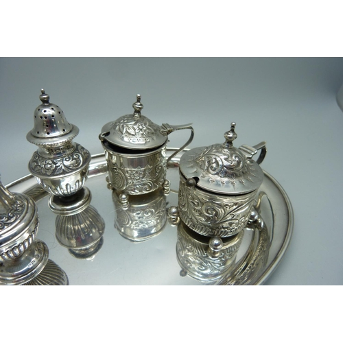 875 - Two Victorian silver rococo style mustards and two Victorian silver peppers with a later oval silver... 